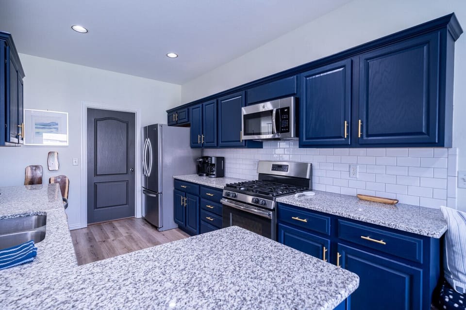 Fully stocked modern kitchen with stainless steel appliances and ample prep space.
