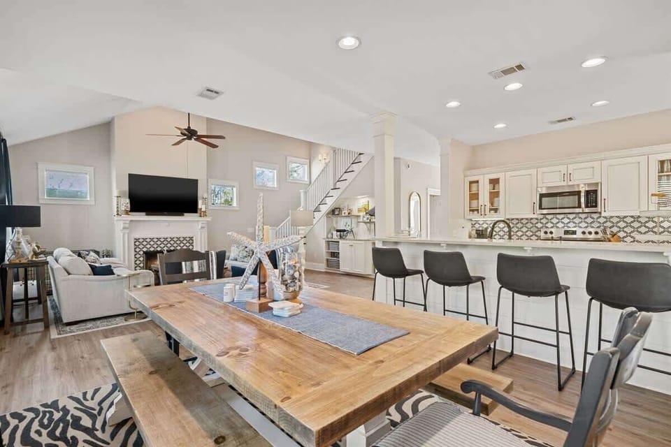 - Gather around the spacious farmhouse style table for meals, games, or evening chats - Open layout blends kitchen, dining, & living areas for effortless connection - Light wood tones, coastal accents, & comfy seating create a warm, relaxed setting
