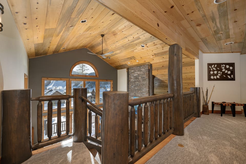 A view from the upper level hall way, showcasing the rustic wooden ceiling giving off that Mountain Cabin vibe