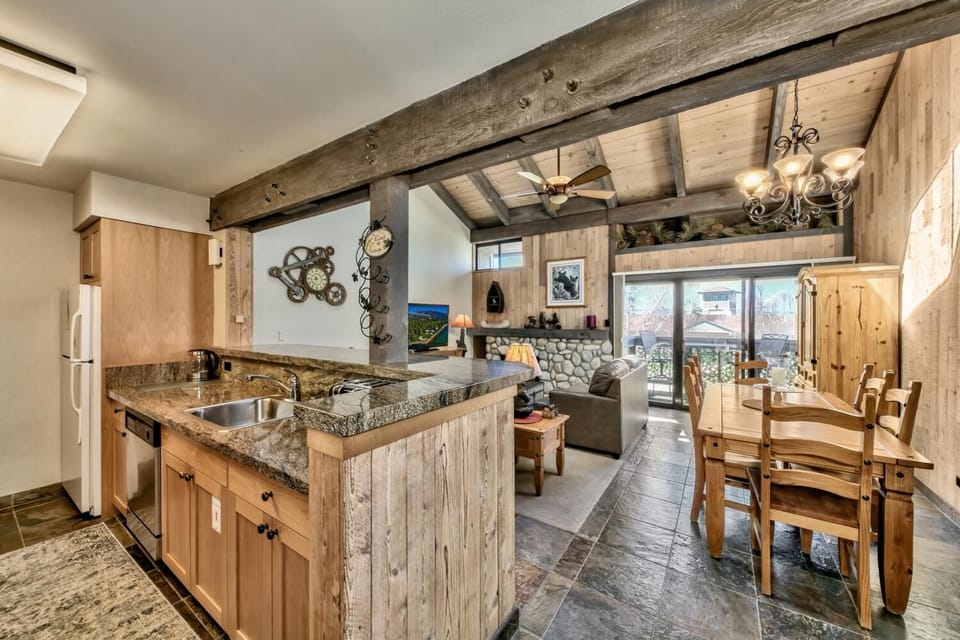 Your rustic-chic kitchen flows seamlessly into the cozy living space, where exposed beams and warm wood create the perfect mountain retreat atmosphere.
