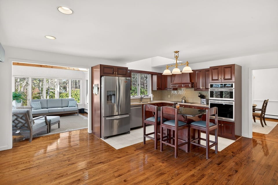 Your gourmet kitchen awaits with rich cherry cabinets, granite counters, and stainless appliances, flowing seamlessly into a bright living space.
