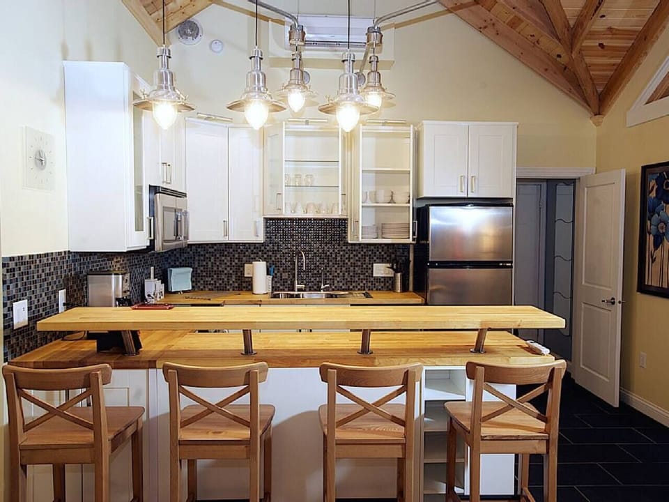 Lights overhead, over- and under-counters illuminate the butcher block countertops in the kitchen area