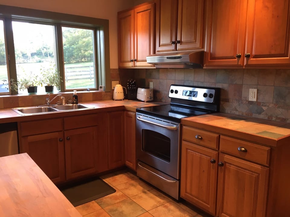 Kitchen equipped with stainless steel appliances and cookware. 