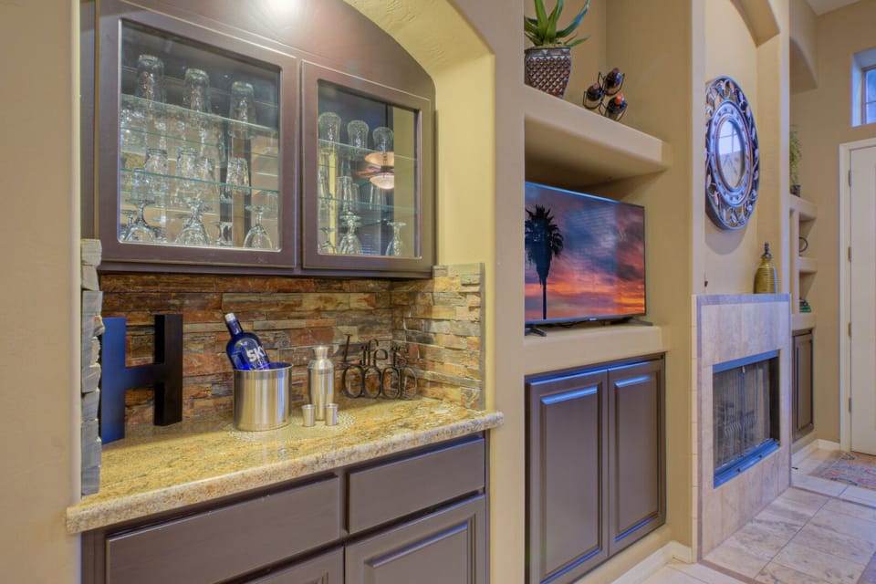Tasteful great room includes a modern bar and smart TV. Fireplace does not work.
