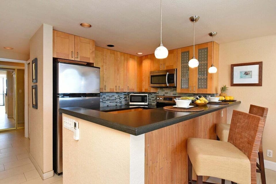 A fully equipped kitchen with sleek appliances and breakfast bar seating—perfect for whipping up fresh local treats.