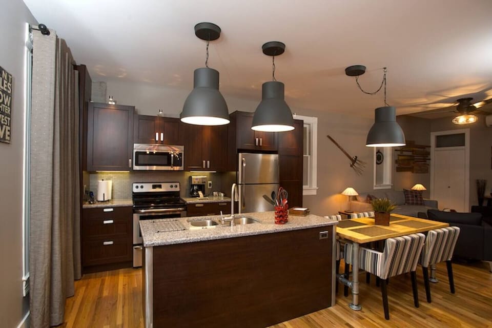 Large kitchen with island and seating for four guests with plenty of overhead lighting