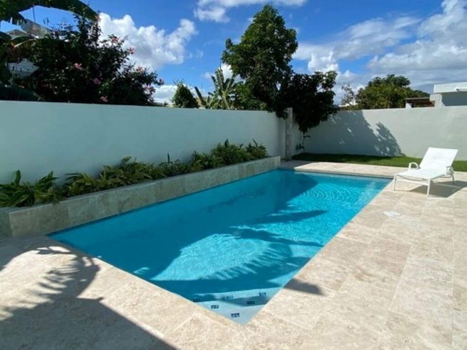 Pool with BBQ and lounge chairs.