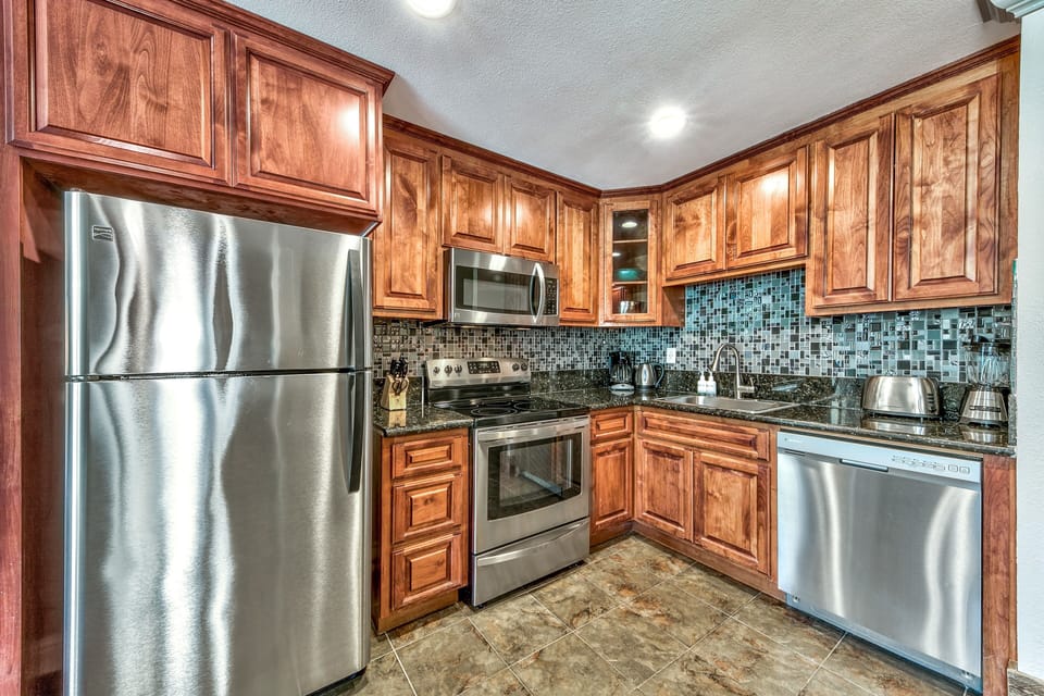 Your fully equipped kitchen features rich wood cabinetry, granite counters, and stainless steel appliances for all your culinary adventures.