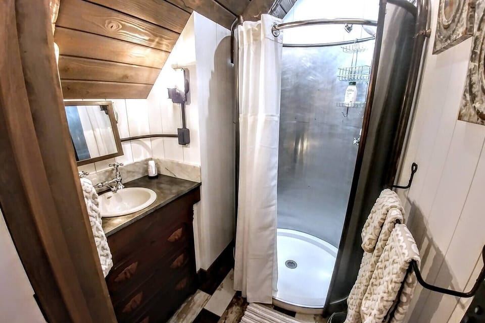 Upper Level Bedroom with oval shower and vanity installed in antique two-drawer dresser