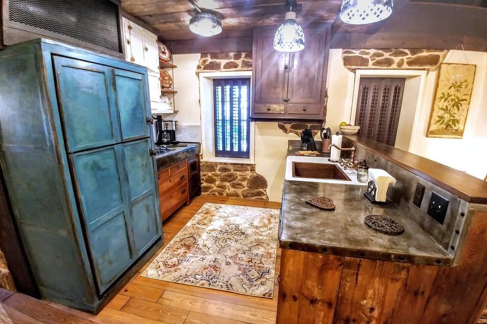 Main level kitchen in the historic Stenhuset features full-size refrigerator, dishwasher, cooktop and convection microwave