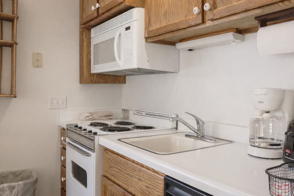 Compact, fully-equipped kitchen with a cozy dining area, perfect for preparing meals during your stay.