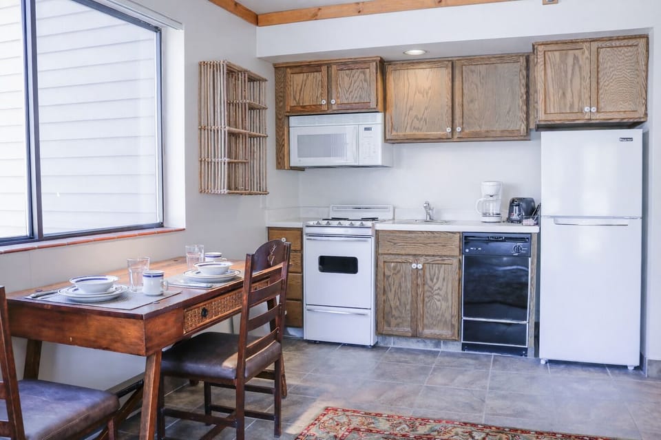 Compact, fully-equipped kitchen with a cozy dining area, perfect for preparing meals during your stay.