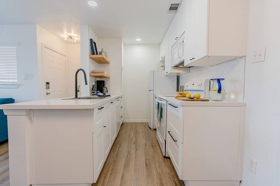Bright, fresh and new galley style kitchen is well stocked with utensils