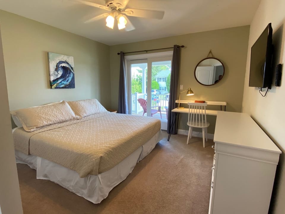 Bedroom 2: King bed on 1st floor with desk/chair, smart TV & front porch access
