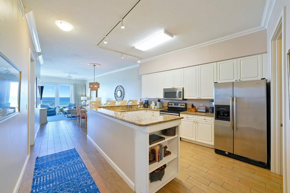 Open-concept kitchen with granite countertops and Gulf-view living area