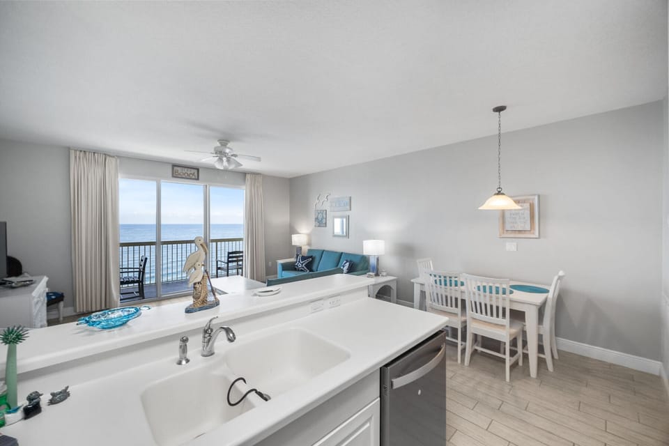 Your open kitchen flows into the living space, where stunning ocean views through floor-to-ceiling windows create the perfect backdrop for your beachfront getaway.