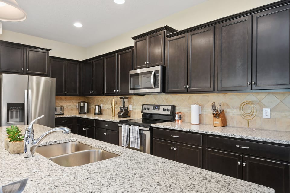 View 2 of stunning modern style kitchen with microwave, stove, oven, and double door refrigerator