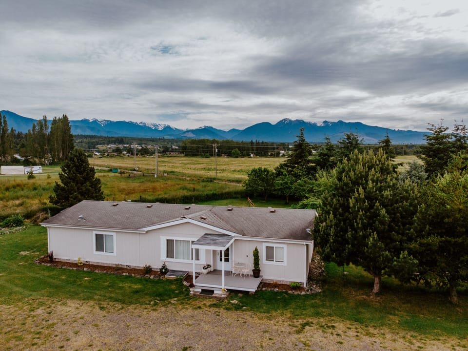 Drone shot of the home with mountain ranges in the backdrop. 