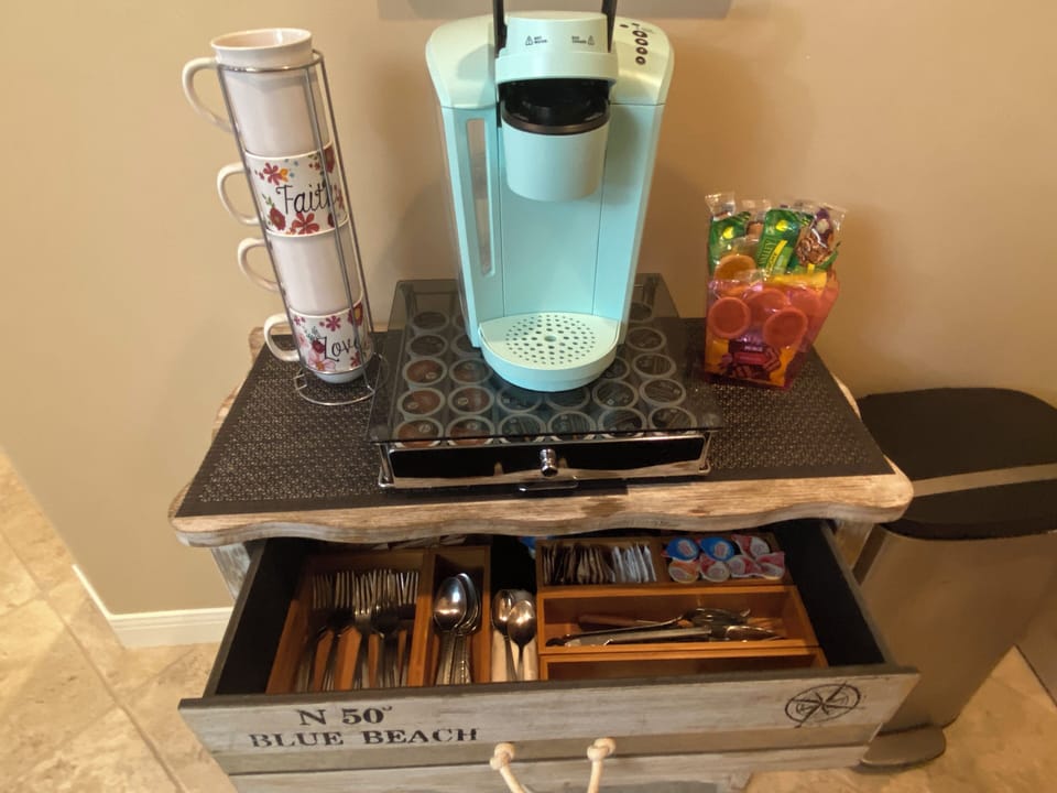 Coffee bar, fully loaded with coffee pods, creamers, sweeteners, and snacks.