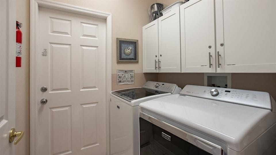 Fully equipped laundry room with washer, dryer, and ample storage space.