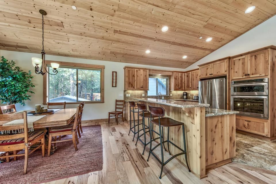 Step into your rustic mountain kitchen where warm wood beams and granite counters create the perfect space for cooking and gathering with loved ones.