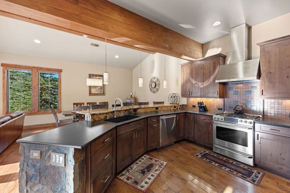 Your gourmet kitchen awaits with granite counters, stainless appliances, and rustic wood beams creating the perfect culinary retreat.
