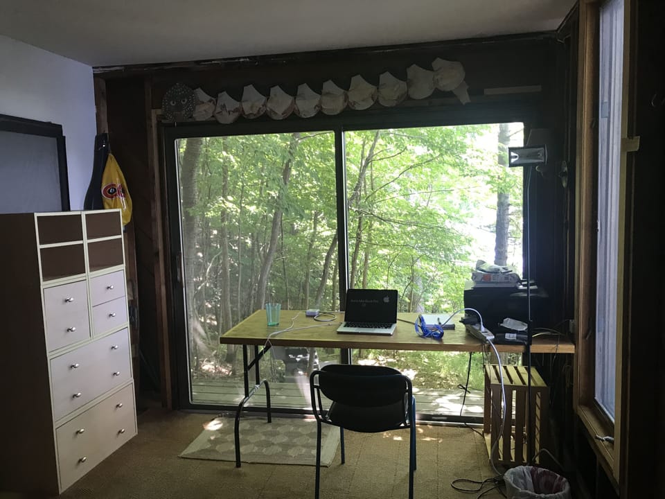Work table and dresser in downstairs bedroom with sliding glass doors.