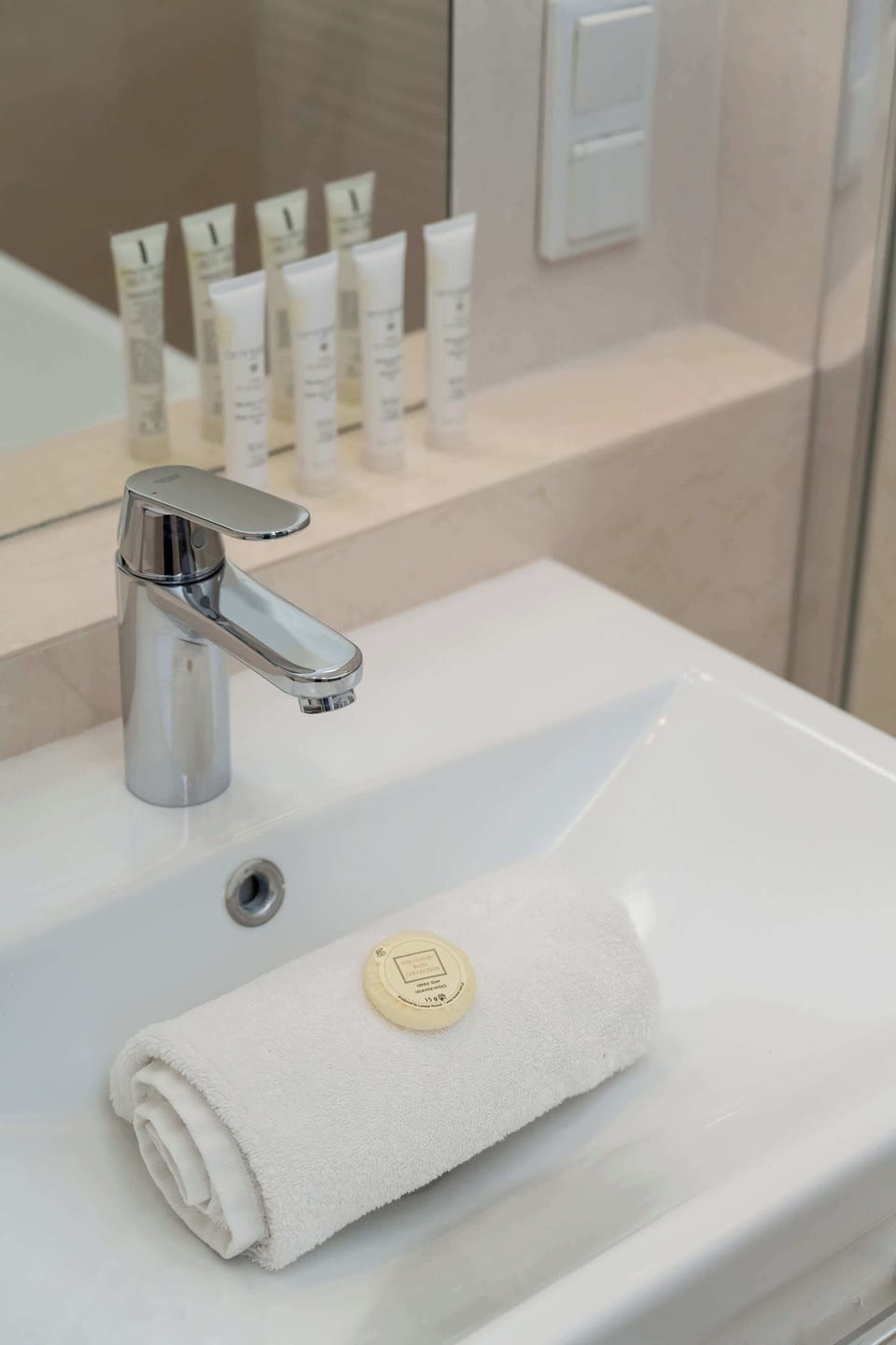 A modern sink with neatly arranged towels and complimentary toiletries, adding a touch of elegance and convenience.

