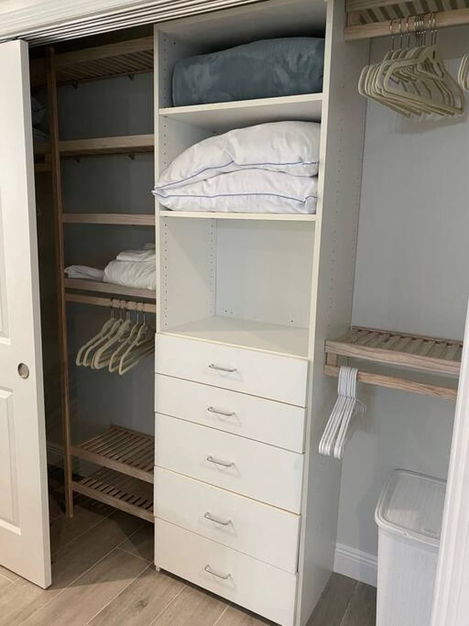 Master closet with lots of hangers and extra bedding.