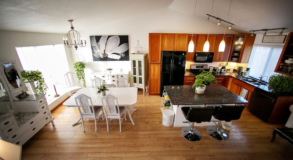 Full view of main level -vaulted ceilings, natural light, and hardwood floors.