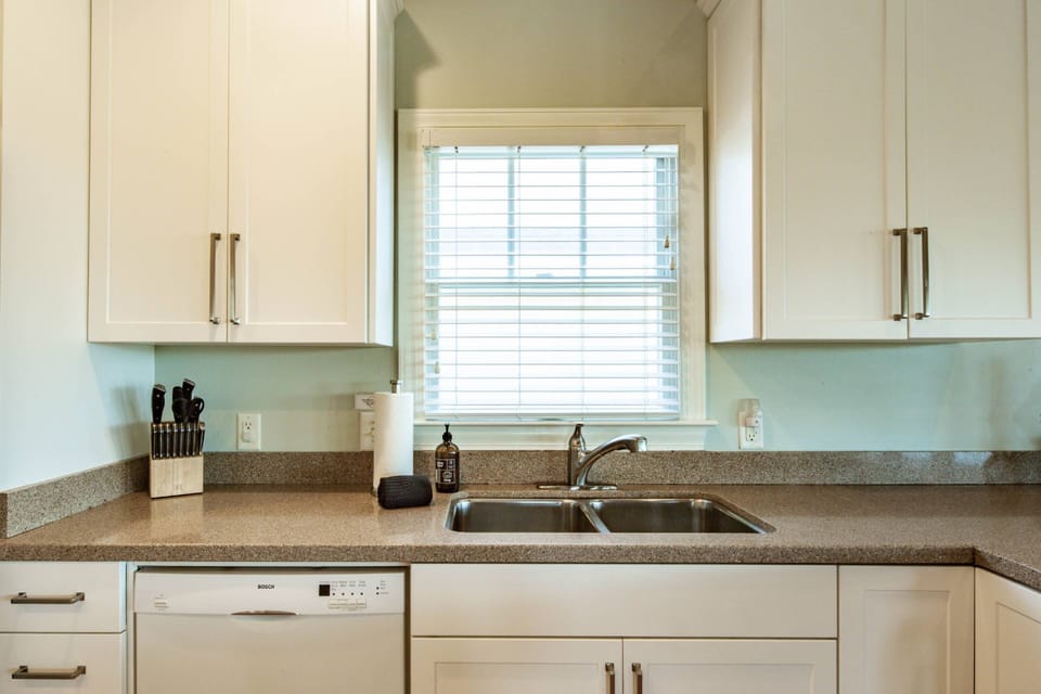 There is a dishwasher in the kitchen adjacent to the sink.