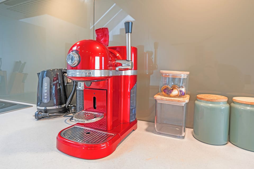 Start your morning with a fresh espresso from the sleek coffee machine, a cheerful touch for easy, barista-style brewing at home.