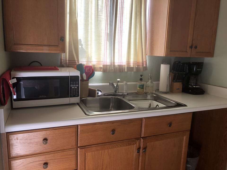 full kitchen sink with microwave and coffeemaker as well