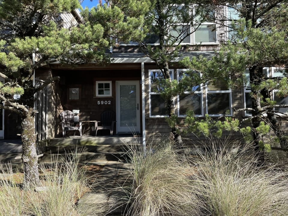 Front door faces Barefoot Lane with porch and chairs to enjoy afternoon sunshine