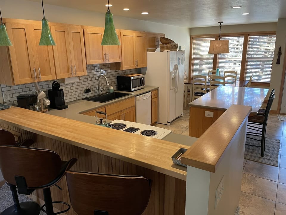 Light & bright kitchen, island, and bar spaces offer lots of room for enjoyment.