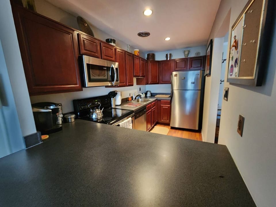 Step into a well-appointed kitchen designed for convenience. It includes a full-sized refrigerator, range, and plenty of counter space for meal prep. You'll find generous storage in the cabinetry, making it easy to keep things organized.