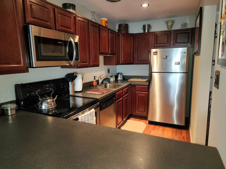 Step into a well-appointed kitchen designed for convenience. It includes a full-sized refrigerator, range, and plenty of counter space for meal prep. You'll find generous storage in the cabinetry, making it easy to keep things organized.