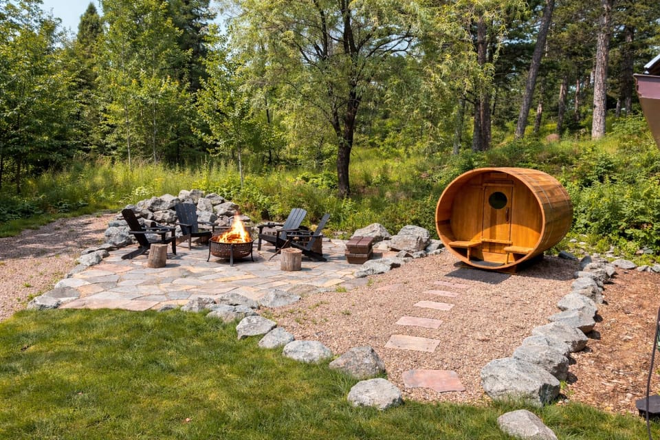 Unwind in your own private outdoor retreat. Soak in the barrel sauna, then gather around the fire pit with comfortable seating, surrounded by natural stone and just steps from the house, perfect for relaxing nights under the stars.
