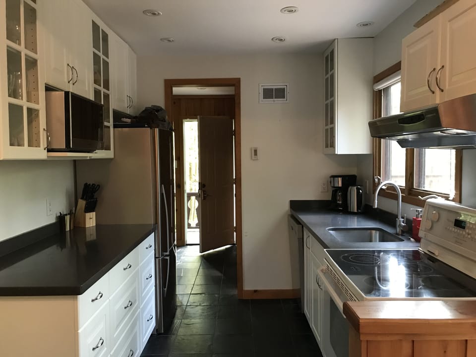 Fully-stocked, galley-style kitchen with full sized appliances. 