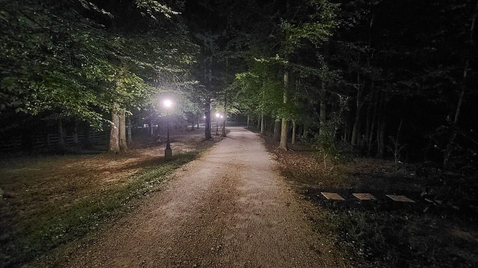 Gravel road lit up at night with post lights for a nightly stroll.