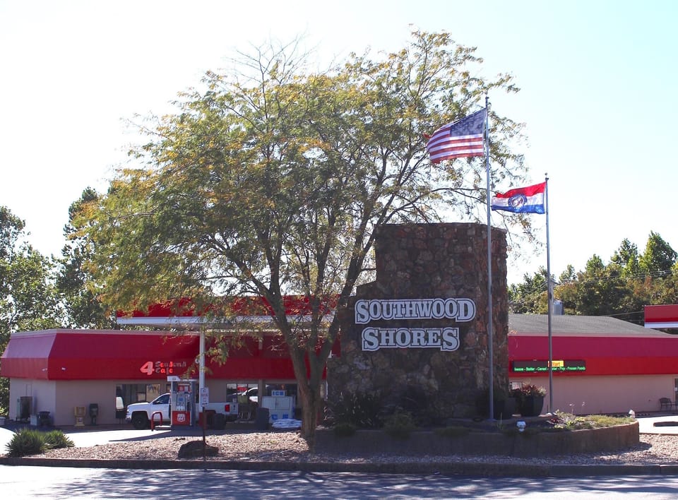 Resort entrance is next to a deli & convenience store
