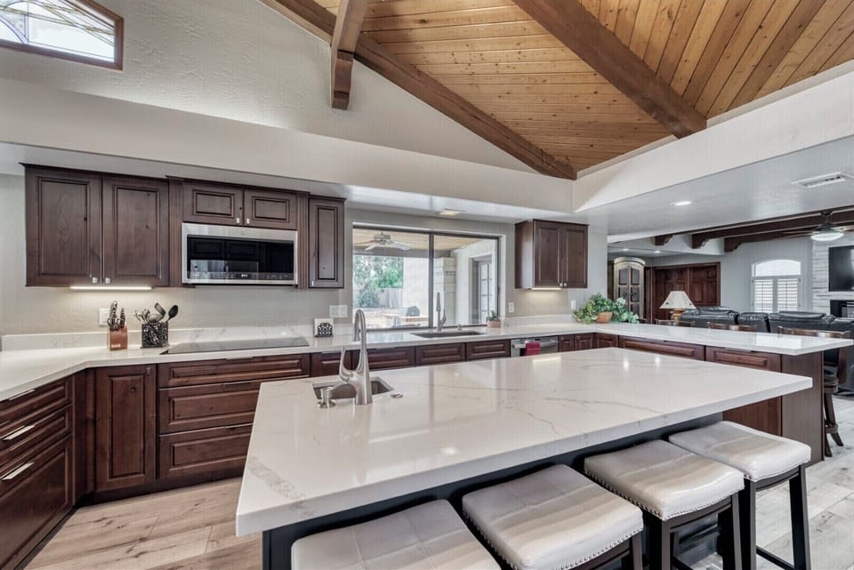 Large center island with seating and prep sink, electric cooktop and microwave