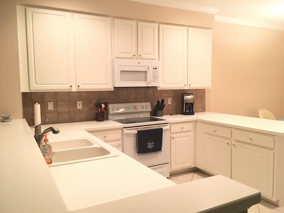 Spacious kitchen with fridge across from stove out of view 