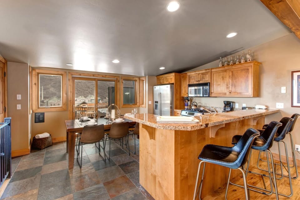 Bright kitchen and dining with granite countertops and mountain views outside.