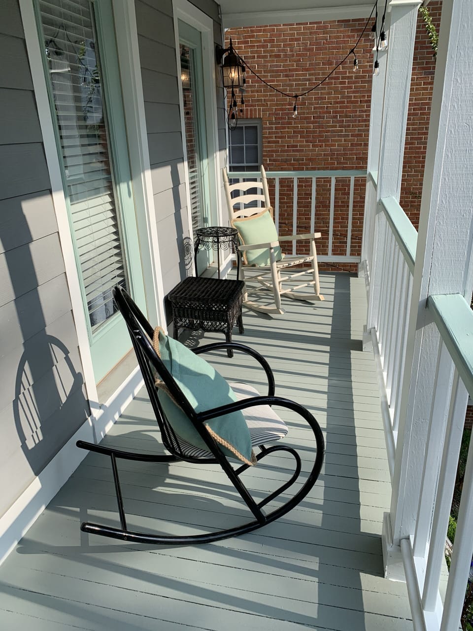 Enjoy your morning coffee in style on a balcony furnished with 2 rocking chairs.