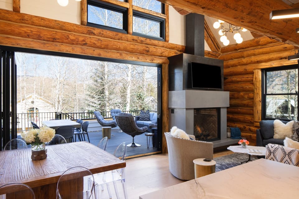 View from kitchen of outdoor dining table and lounge swivel chairs