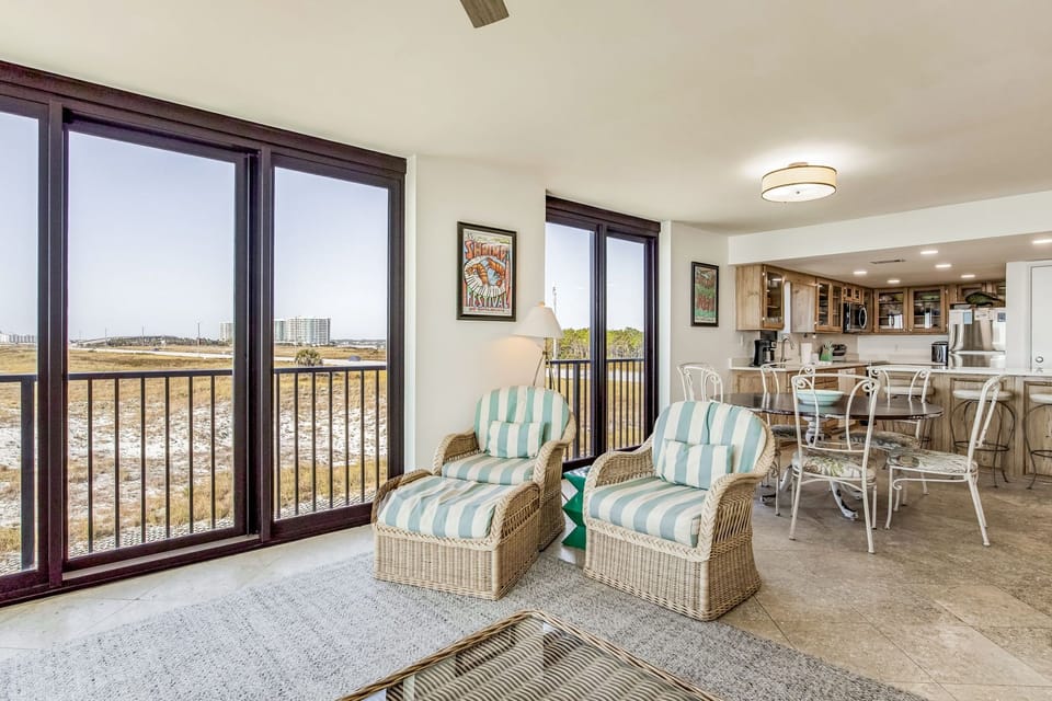 Open-concept living and dining with Gulf-view balcony access at Wind Drift 212 SW
