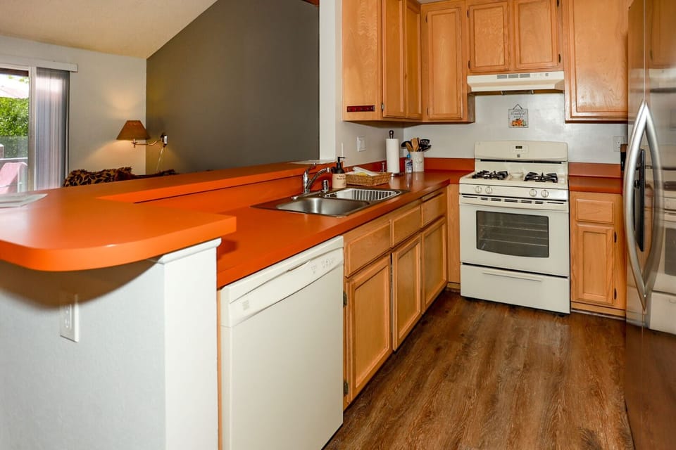 Modern kitchen with sleek countertops and bright finishes, perfect for cooking and entertaining guests.