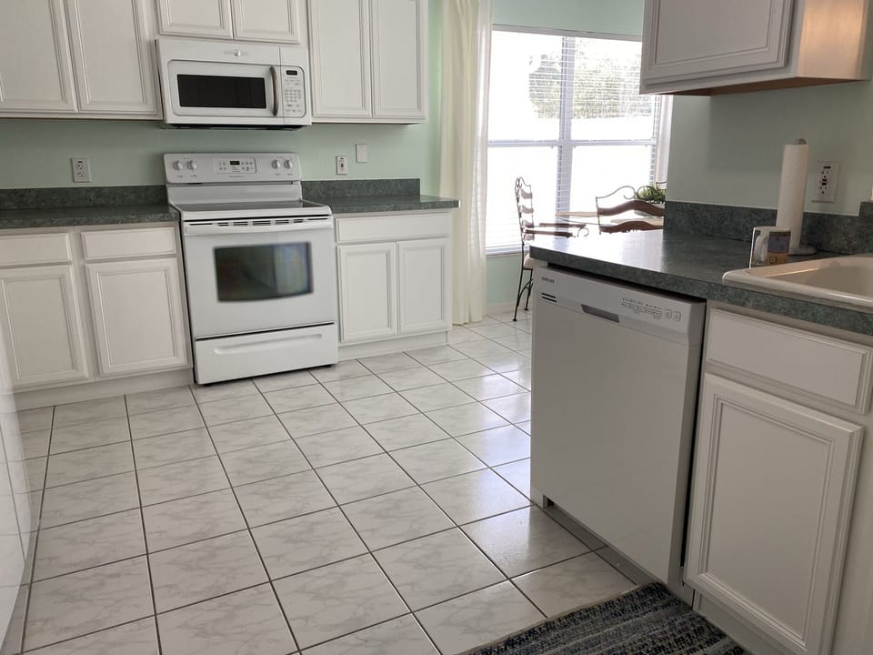 Kitchen. Open clean, bright, lots of dishes, glasses, utensils. 