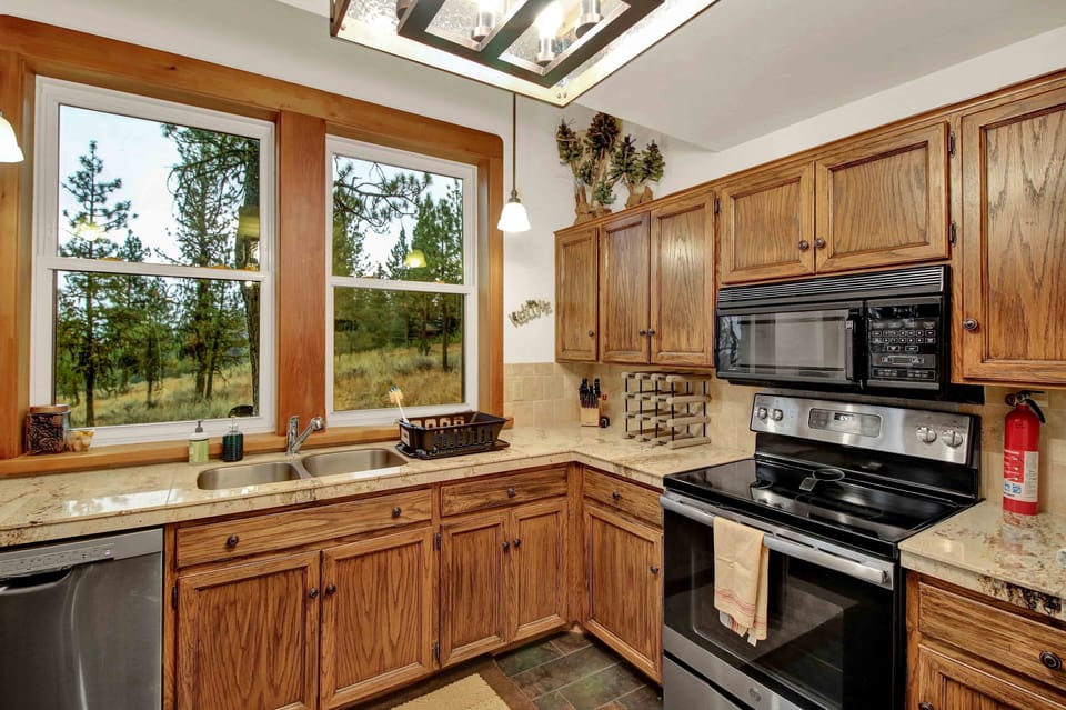 Well appointed kitchen with dishwasher, stove/ oven, microwave, and views.